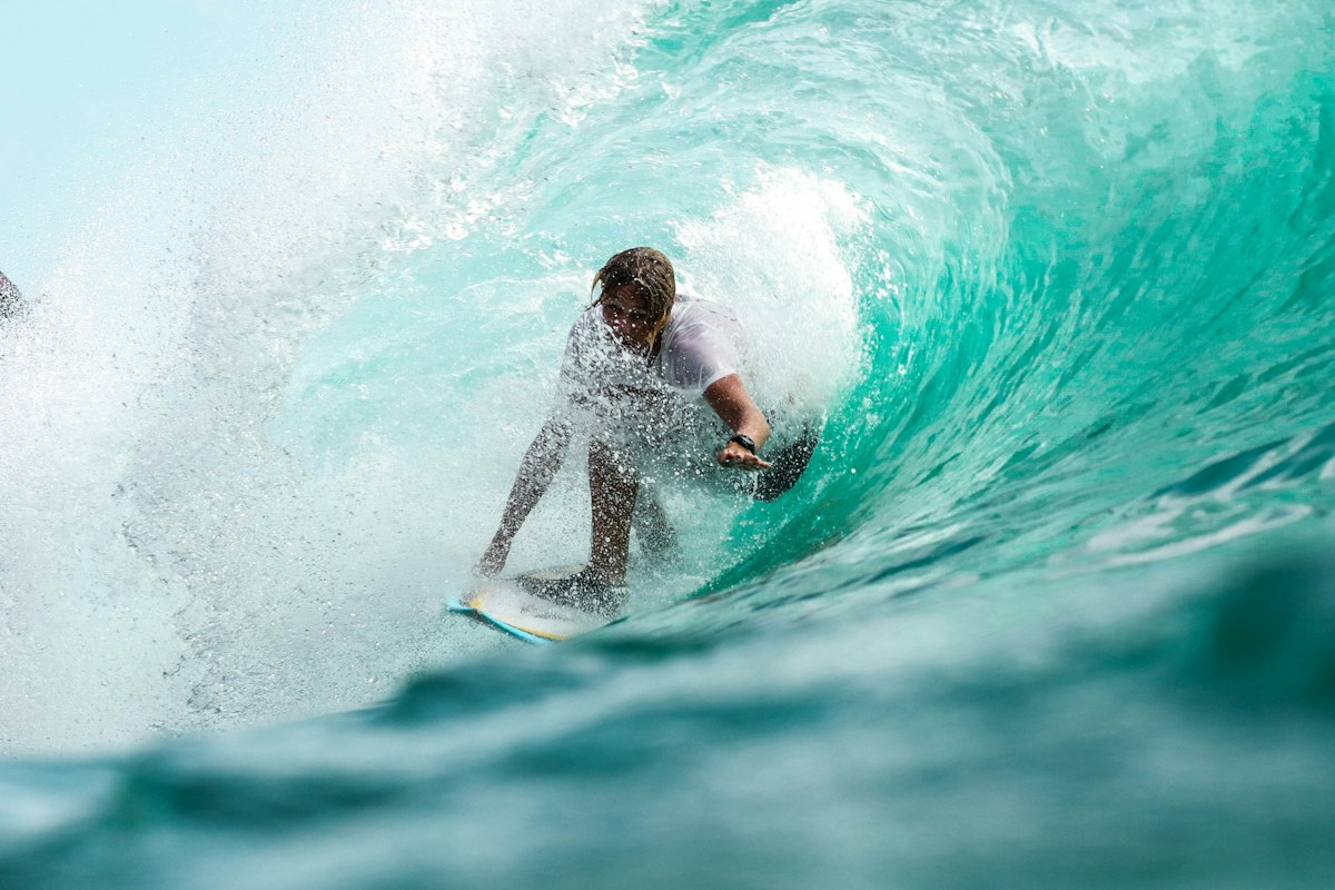 Surfer riding a clean blue wave on an open coast