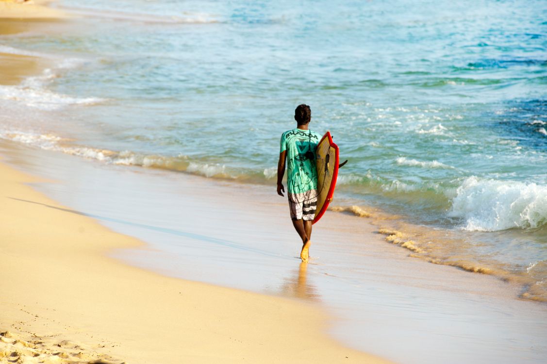 Surfer walking to the water with a board