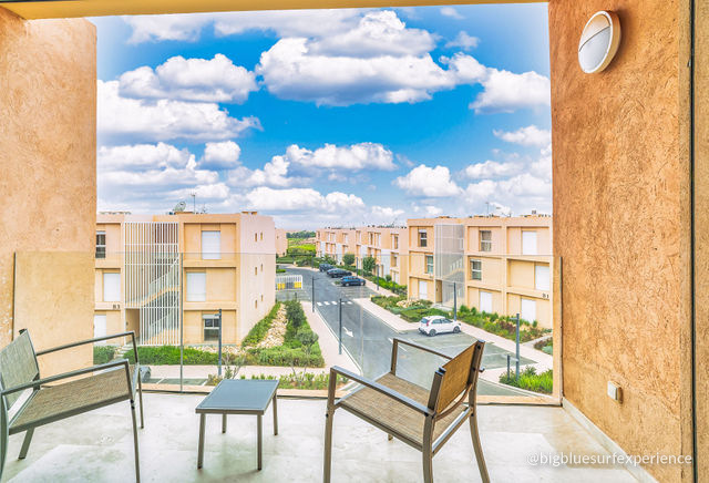 Balcony of the BigBlue Bay Duplex with two chairs and a low table over the residence
