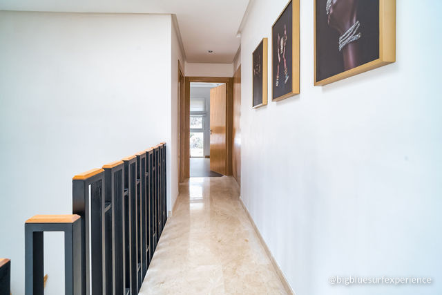 Landing on the upper floor of the BigBlue Bay Duplex with the stair railing and marble floor