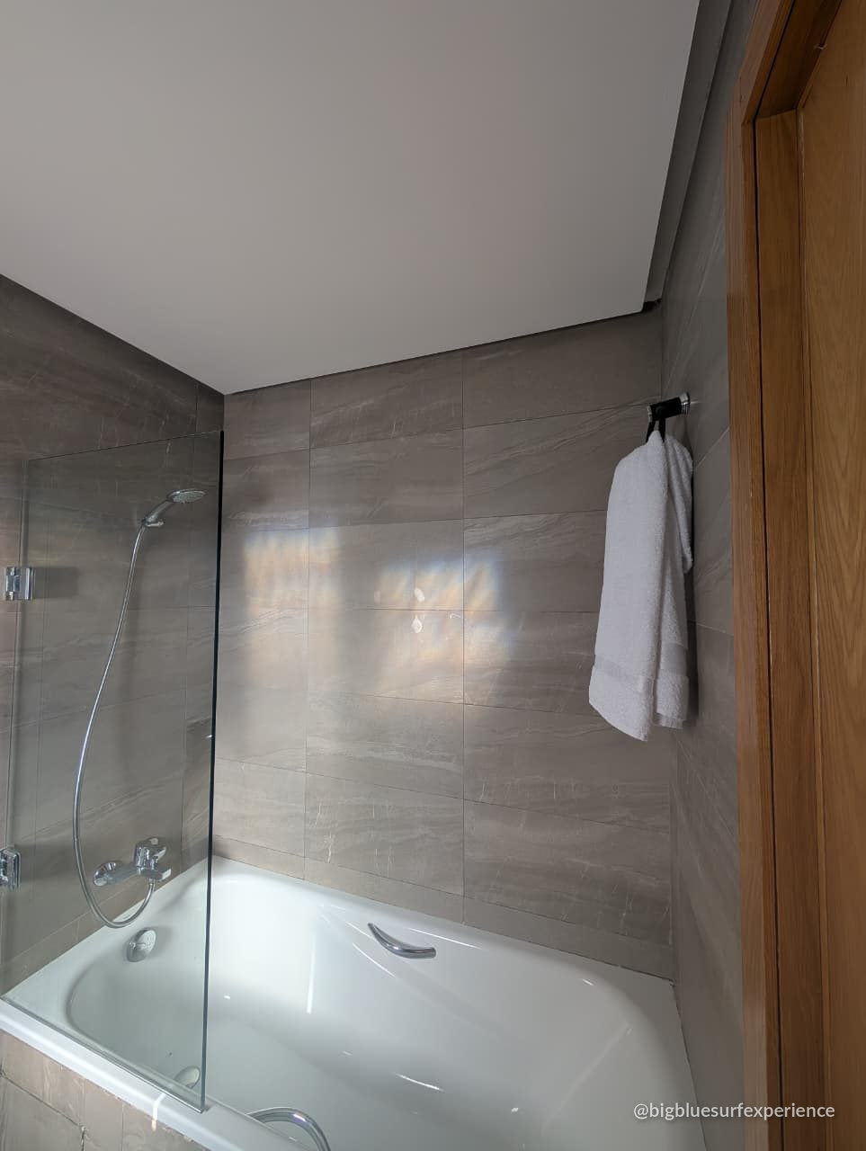 En-suite bathroom of the BigBlue Bay Studio with a bath and a glass screen