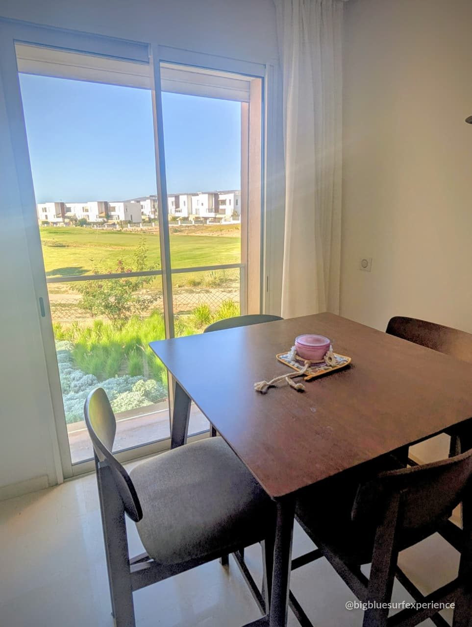Dining table for four beside the balcony doors of the BigBlue Bay Studio