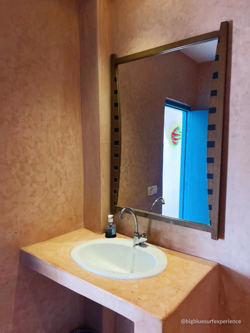 Tadelakt washbasin and mirror in a guesthouse bathroom