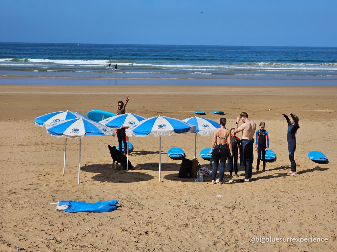 BigBlue coach briefing a small group on the beach before a surf session